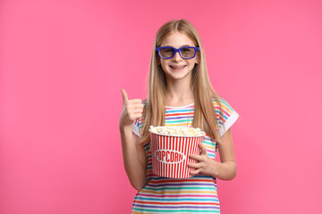 Canvas Print - Teenage girl with 3D glasses and popcorn during cinema show on color background