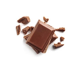 Wall Mural - Pieces of tasty milk chocolate on white background, top view