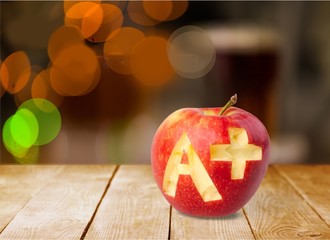 Wall Mural - Photo of red apple with A+ on the school desk