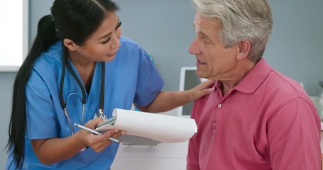 Wall Mural - Supportive nurse putting hand on shoulder of senior patient while listening