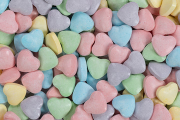 Pastel colored candy hearts macro background