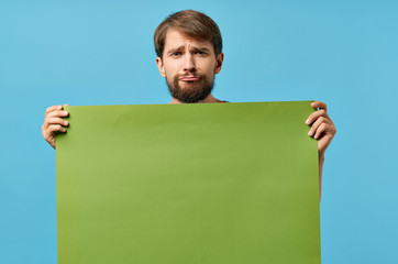 a man with a beard holds a green background place free