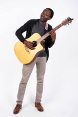 Full body shot of handsome African man playing the guitar