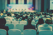 © THANANIT - Rear view of Audience listening Speakers on the stage in the conference hall or seminar meeting, business and education about investment concept