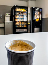Plastic Coffee Cup Of Vending Machine Standing On Table