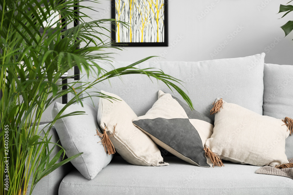 Stylish grey sofa in interior of room