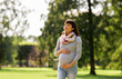 © Syda Productions - pregnancy, people and motherhood concept - happy pregnant asian woman walking at park