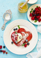 Wall Mural - Pancakes red velvet in the form of a heart with berries and cream. Valentine's Day. Selective focus.