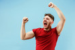 I won. Winning success happy man celebrating being a winner. Dynamic image of caucasian male model on blue studio background. Victory, delight concept. Human facial emotions concept. Trendy colors