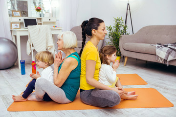 Pleasant calm nice family practicing yoga together