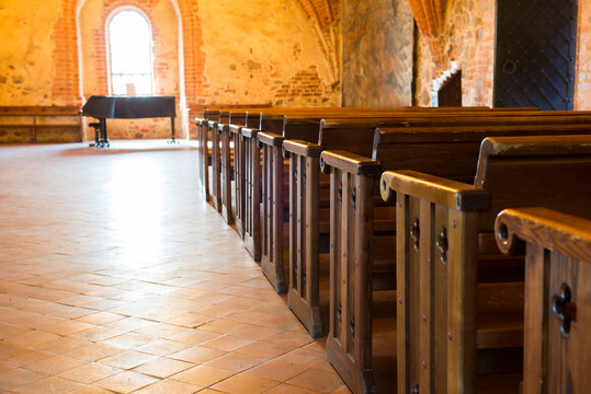 Row of empty wooden seats in catholic church