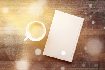 Sticker - Cup of hot coffee with notebook on wooden table background, top