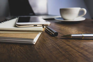 Office desk table with notebook, computer keyboard, mobile phone and other office supplies. Top view with copy space, flat lay. vintage background.