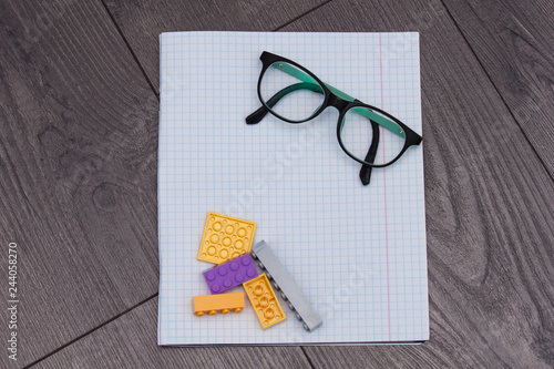 Fotografía Eye glasses with notebook, constructor on wooden background