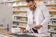 Pharmacist writing prescription pharmacy counter