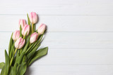 Fototapeta Tulipany - A bouquet of tulips on a wooden background top view. Spring background. Background to Mother's Day, International Women's Day, birthday.