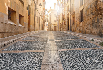 ancient street with gray pavement bridge of ancient Spain city Tarragona on sunny day