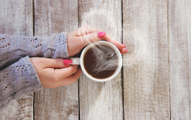 Wall Mural - A cup of tea in the hands of a man and a woman. Selective focus.