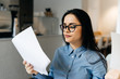 © mnelen.com - business successful business woman in glasses works in a cafe, holds documents in hands