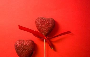 Red background. St. Valentine's Day. Red hearts in spangles and with bows. Love. Romanticism. The place for an inscription.