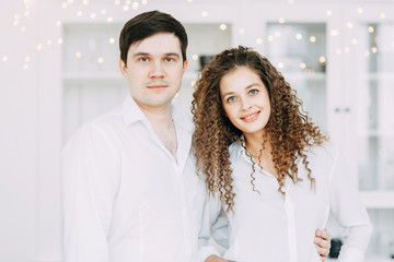 Young couple eating sweets at the table. Photo shoot in a bright interior Studio for the New year.