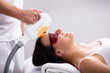 © Andrey Popov - Beautician Giving Laser Depilation Treatment To Woman Face