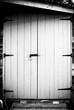 black and white image of an old wooden door with lock