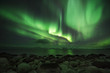 Northern light at the shore of the Barents sea. Rocky shore nearby of Murmansk.