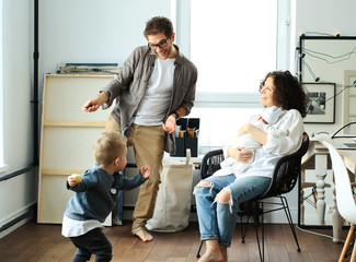 Wall Mural - Happy young family laughing and dancing at home