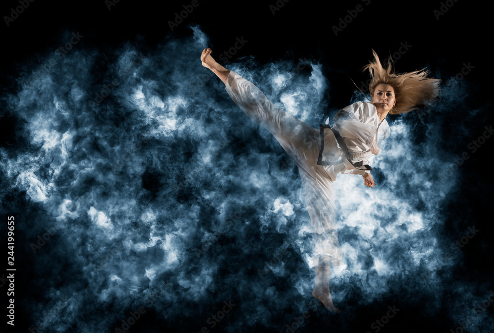 Fotografering Woman in kimono practicing taekwondo