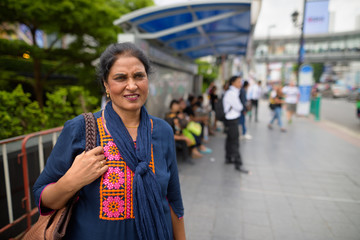 Mature beautiful Indian woman smiling in city