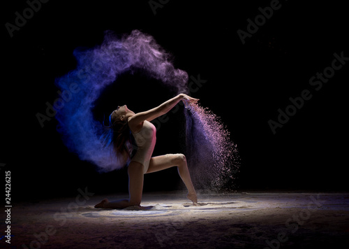 Brunette on her knees in color dust in the dark Canvas