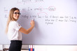 © Elnur - Young female english language teacher standing in front of the b