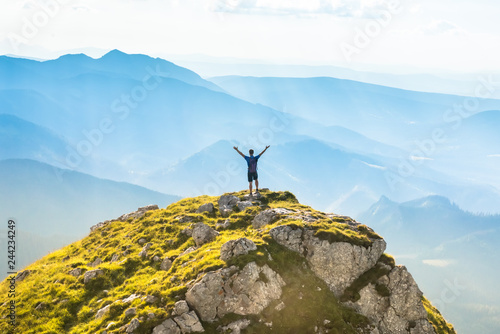 Fotomural silhouette of successful man on the top of mountain