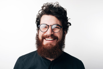 Portrait of beautiful mature bearded guy in dark blue shirt with stylish hair smiling and looking in camera