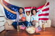 © Mediteraneo - Happy African American family of three watching tv and cheering sport games on sofa at home