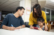 © chotiga - Family spending time together at library,holding mobile phone and books in hands