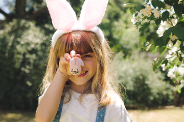 Portrait of a little girl showing a painted easter egg