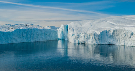 Wall Mural - Iceberg aerial photo - giant icebergs in Disko Bay on greenland floating in Ilulissat icefjord from melting glacier Sermeq Kujalleq Glacier, aka Jakobhavns Glacier. Global warming and climate change