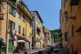 Fototapeta Na drzwi - A typical colourful street in Nice, France, with beautiful apartment blocks above the shops and restaurants below