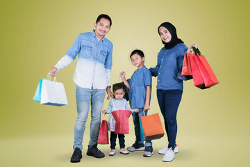 Wall Mural - Asian family holding shopping bags on studio