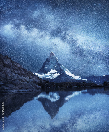 Leinwand Poster  Matterhorn and reflection on the water surface at the night time