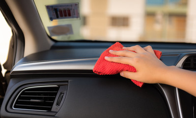 Closeup woman hand is washing and cleaning with microfiber at console panel inside a car., Car maintenance service and transportation concept.