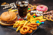 Junk food concept. Unhealthy food background. Fast food and sugar. Burger, sweets, chips, chocolate, donuts, soda.