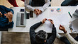 © alfa27 - Top view of multiracial creative business men in white and black formal clothes disputing at a meeting using gadgets during the conference while sitting at the modern office.