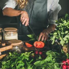 Woman cutting fresh tomatoes on concrete kitchen counter, square crop