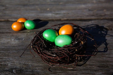 Colorful Easter egg in the nest on wooden background