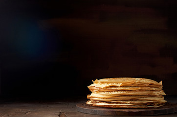 Stack of russian pancake blini on a wooden background