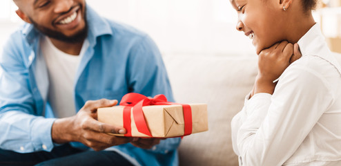 Wall Mural - Happy girl receiving gift from father at home