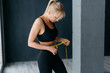 © MZaitsev - Athletic slim woman measuring her waist by measure tape